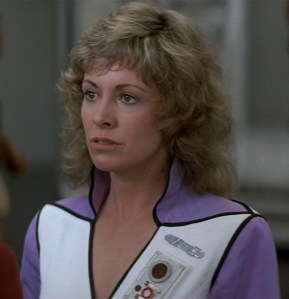 I don't normally say this about older women from the '80s with big hair... but what a stone-cold fox. And that v-neck uniform...